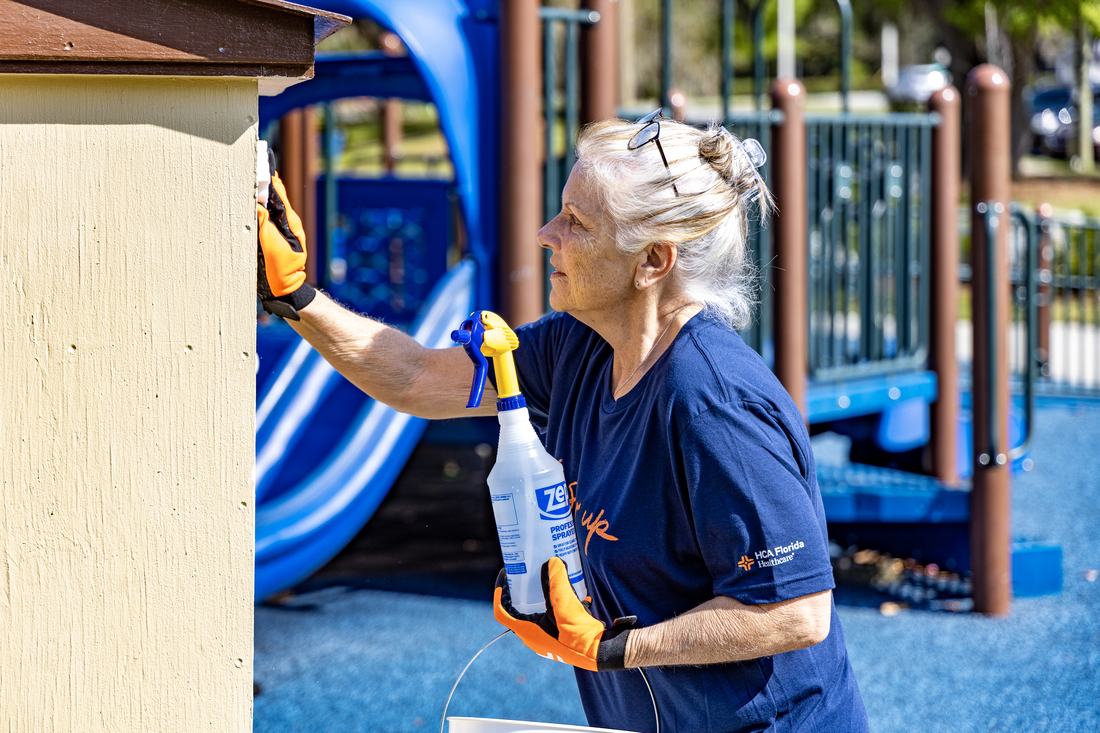 Our colleagues show up for our patients, our communities and each other. Pictured is an HCA Florida Healthcare colleague showing up for our communities by volunteering to help keep playground equipment at local parks clean.