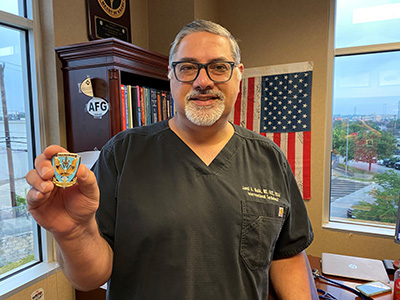 Dr. Malik holding the military challenge coin.