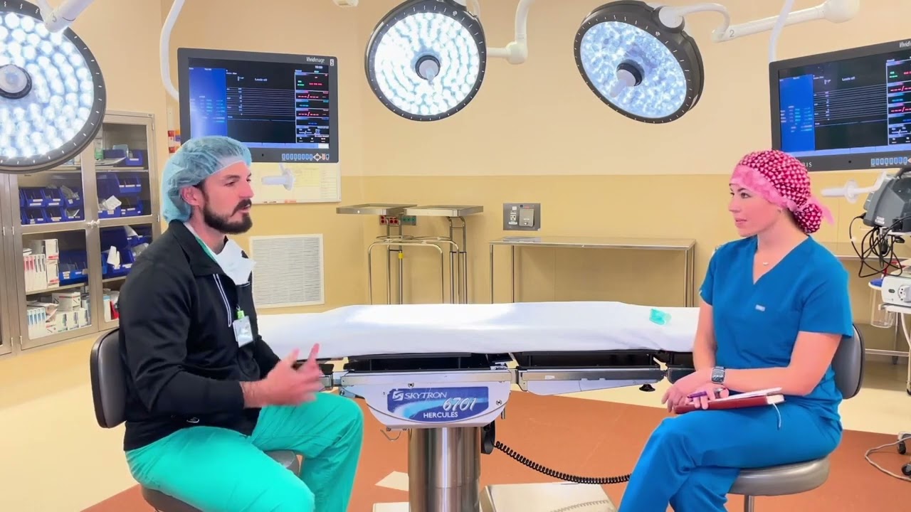 Alvaro Bada, Jr., M.D., discusses hernia care with a nurse.