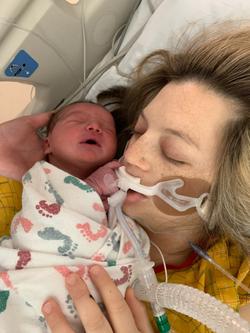 Dr. Carmen Vandal, in ICU with breathing tube, holding her newborn baby