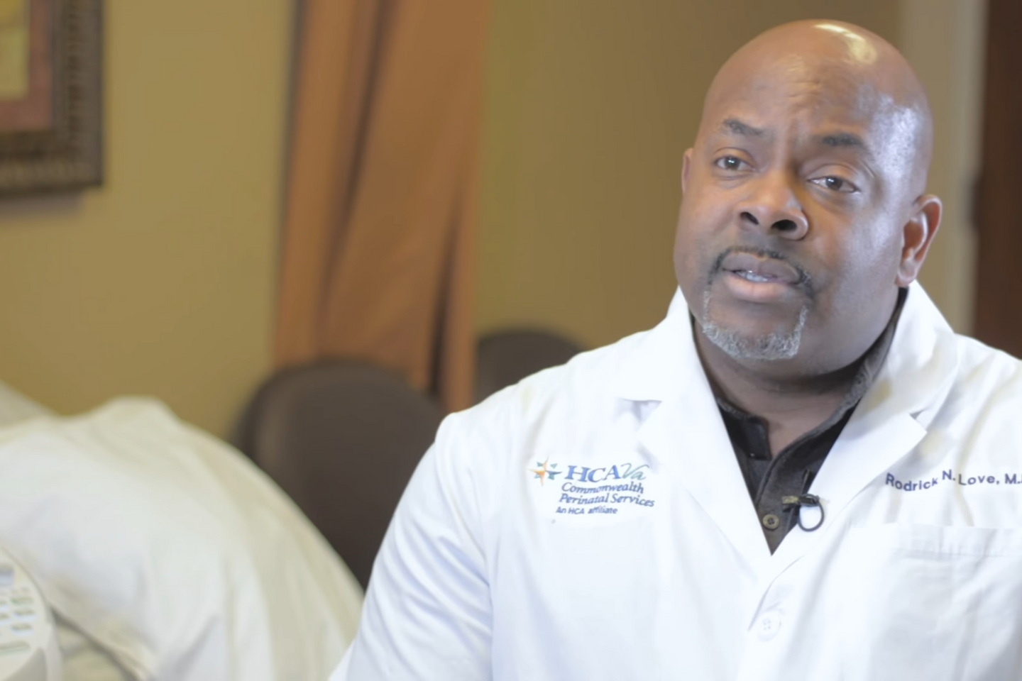 Physician Rodrick N. Love is seated and wearing a white lab coat