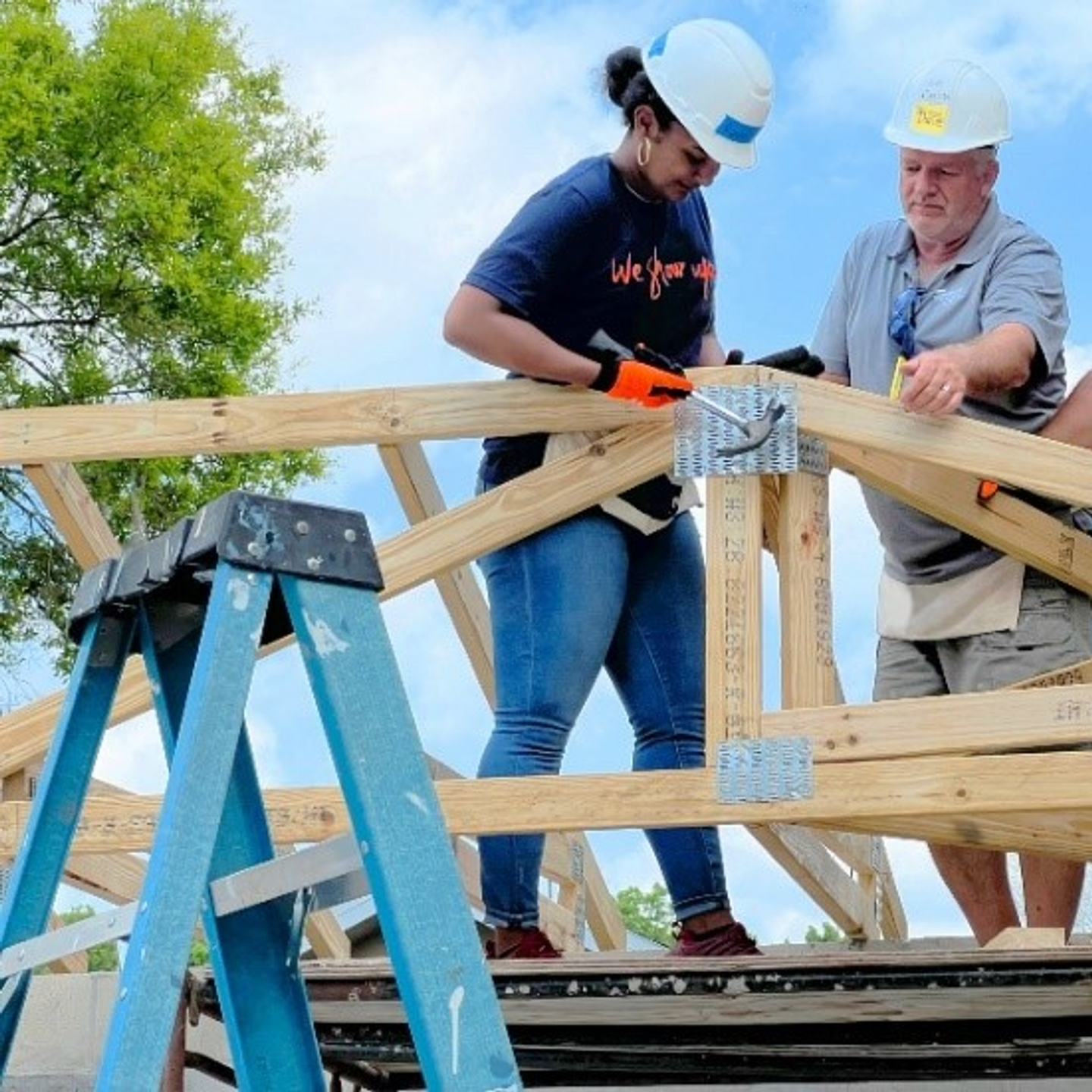 HCA Florida Brandon Hospital GME Coordinators Raven Moore and Israel “Tony” Marmolejos work with Contractor Dale Munsell to build one of 32 trusses for a Habitat for Humanity Plant City home that HCA Florida Healthcare volunteers constructed during the second statewide We Show Up for Our Communities Week.