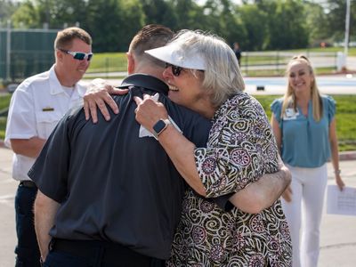 Elizabeth White hugs member of the EMS team that responded to her 911 call.