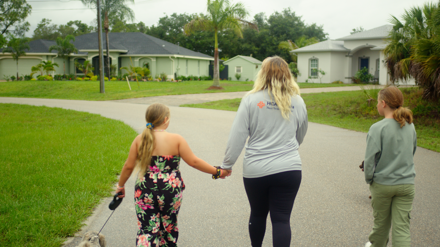 Kimberly Cansler and her children walk their dog in their neighborhood