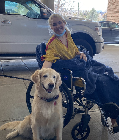Hailey Harsch in a wheelchair with her dog.