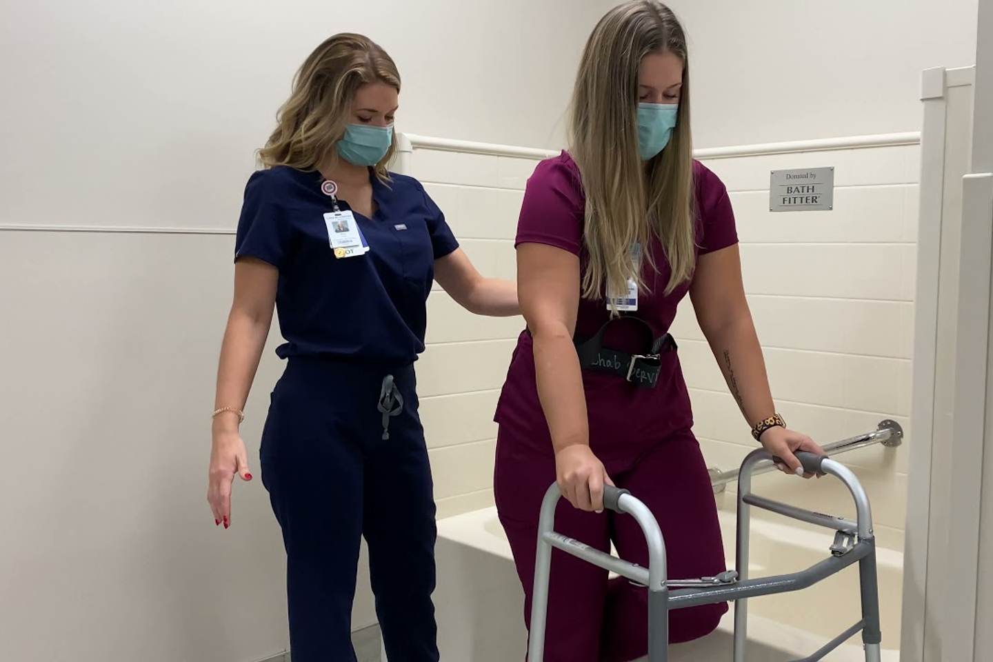 Occupational therapist assisting  a patient on a walker.