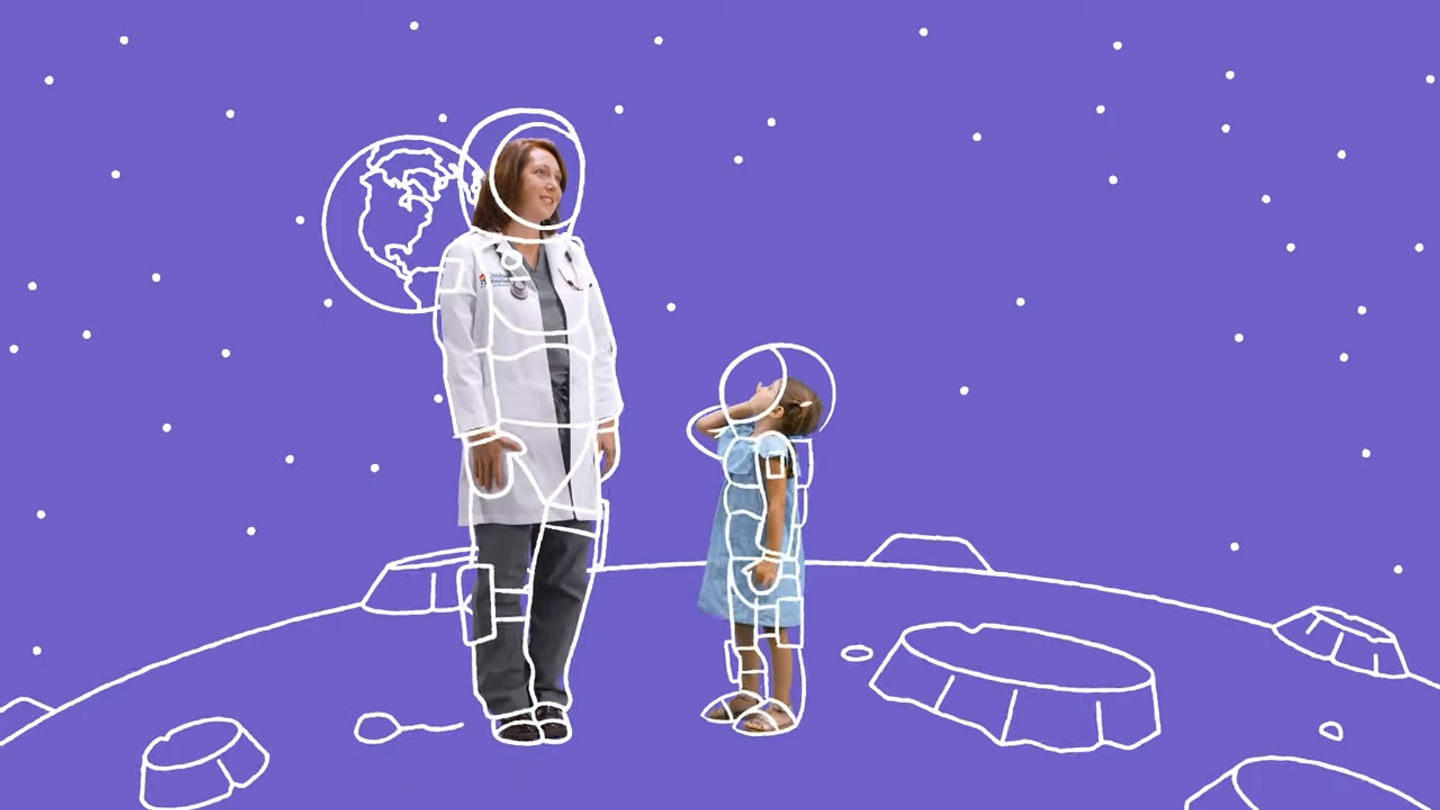 A doctor and a child pretend to be astronauts on the moon.