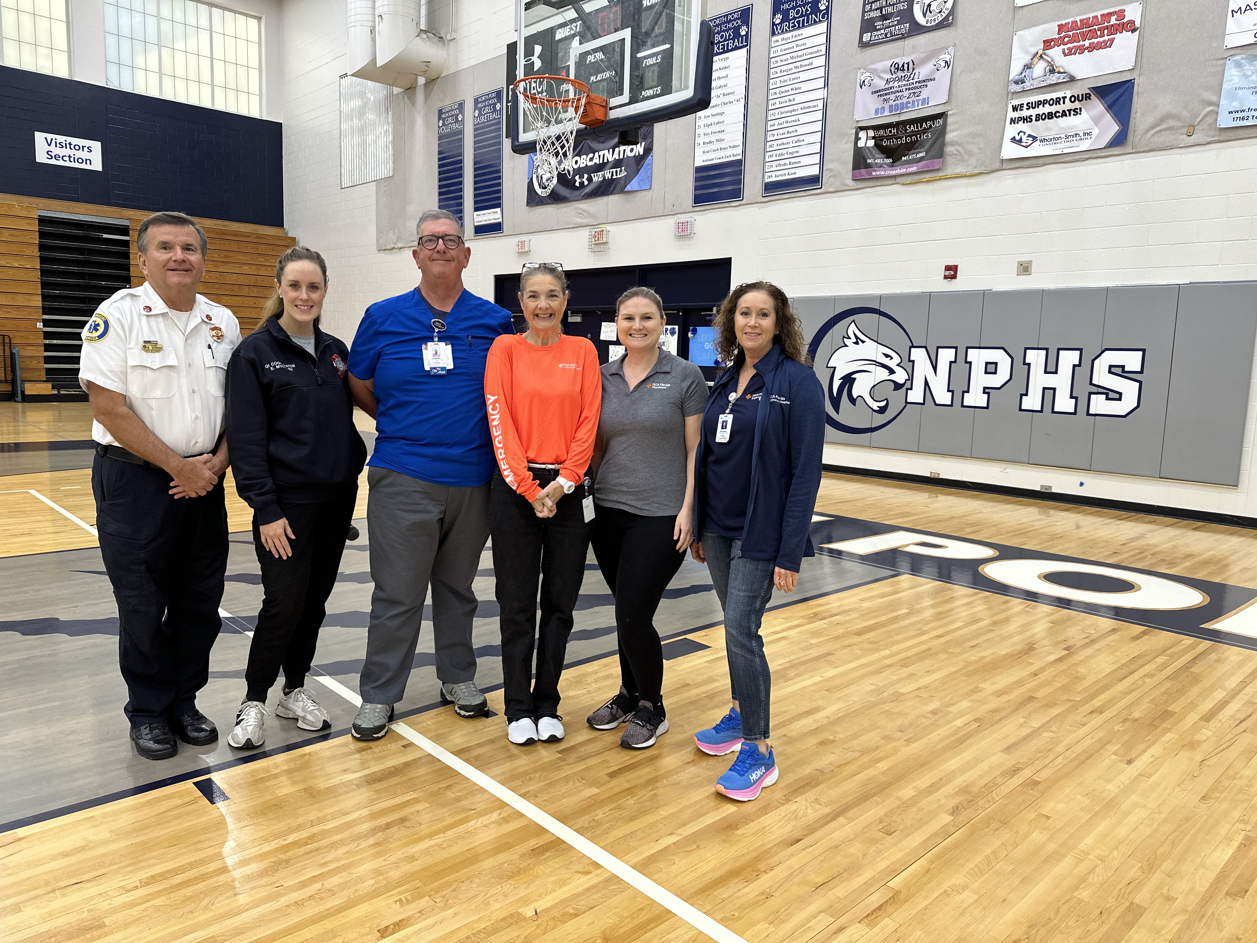 HCA training staff poses in school gymnasium.