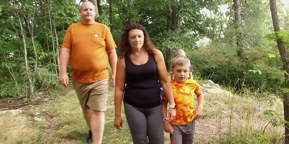 Heather Umberger walks with her family in the woods.