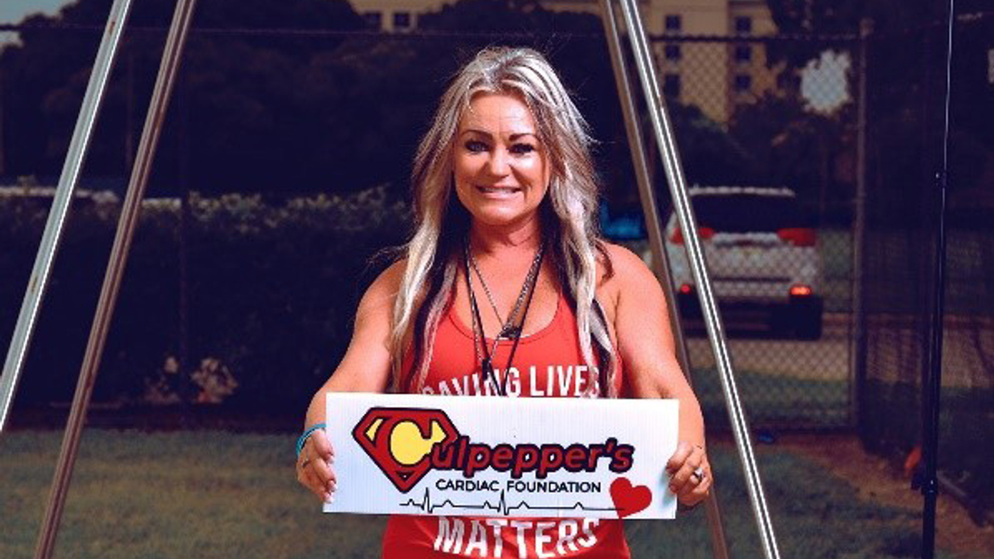 Melanie Brown Culpepper holding Culpepper Cardiac Foundation sign.