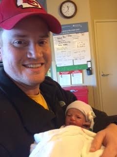 Brant Schumaker holding his newborn baby.