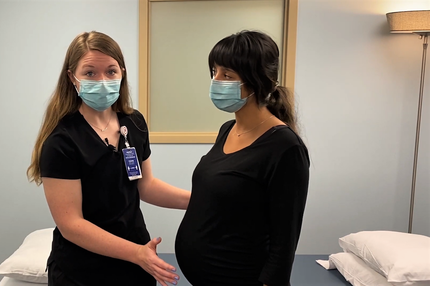 Colleen Gensheimer wears a mask while consulting pregnant, masked patient.