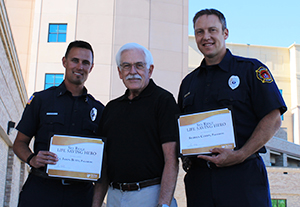 Doug presenting the "Live Saving Hero Award" to paramedics Lt. Jason Butts and Stephen Coffin.