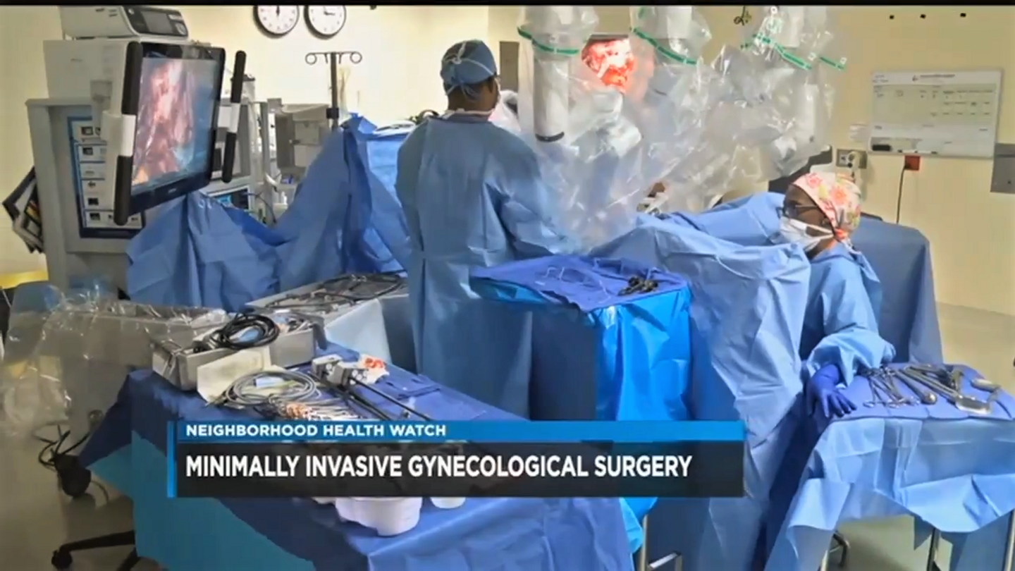 Medical team performing minimally invasive gynecological surgery in a hospital surgical room.