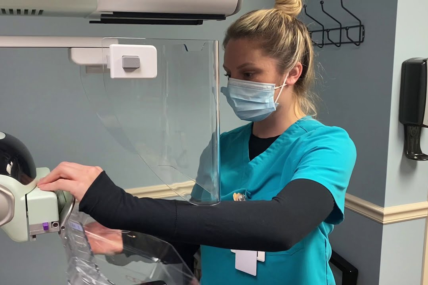 Nurse of TriStar Southern Hills East, wearing blue scrubs, using an imaging device.