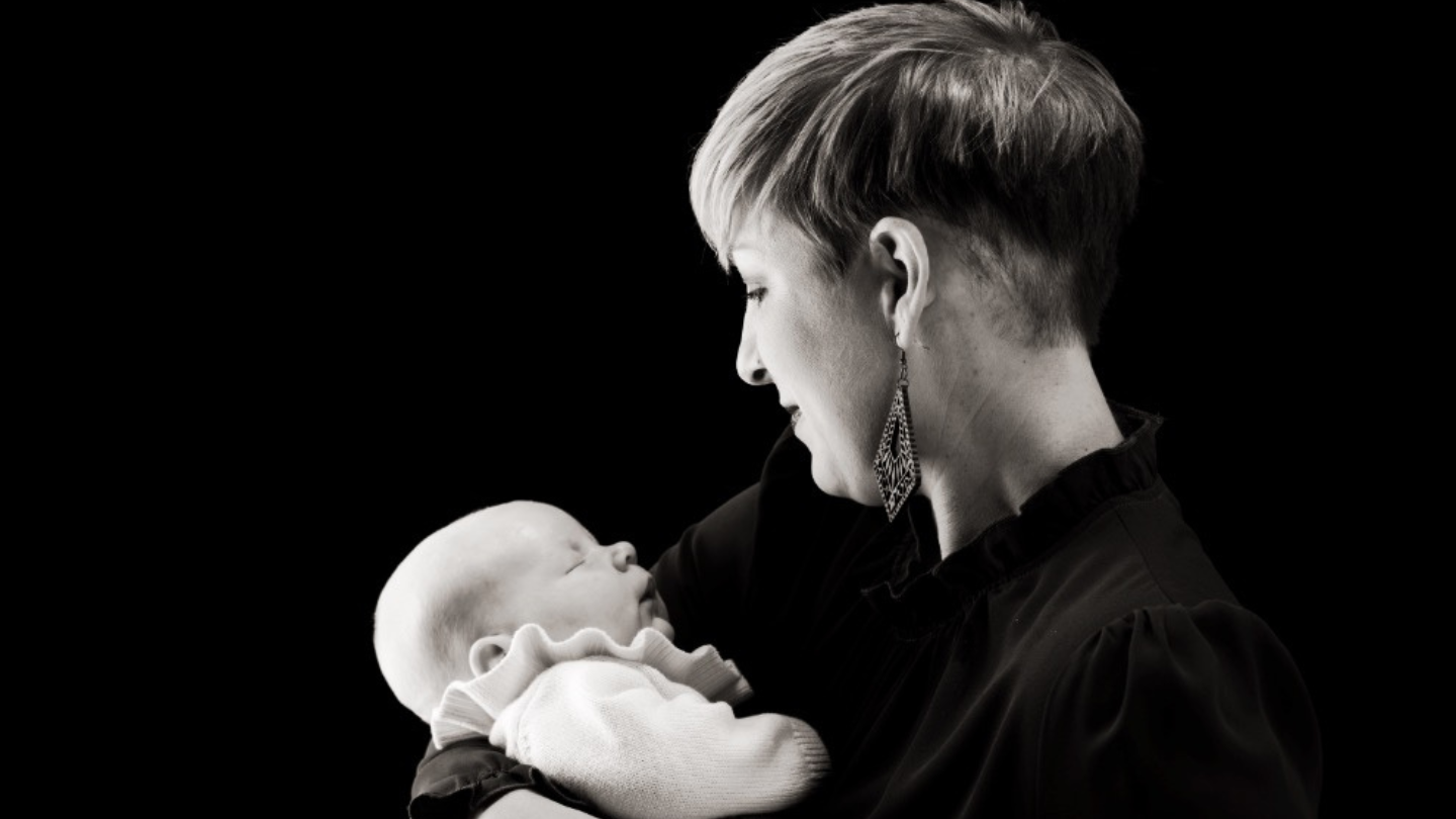 Michaela pictured holding her baby in black & white
