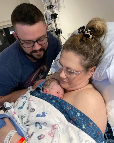 Katelyn Churchill in a hospital bed, with her husband and baby Charlotte.