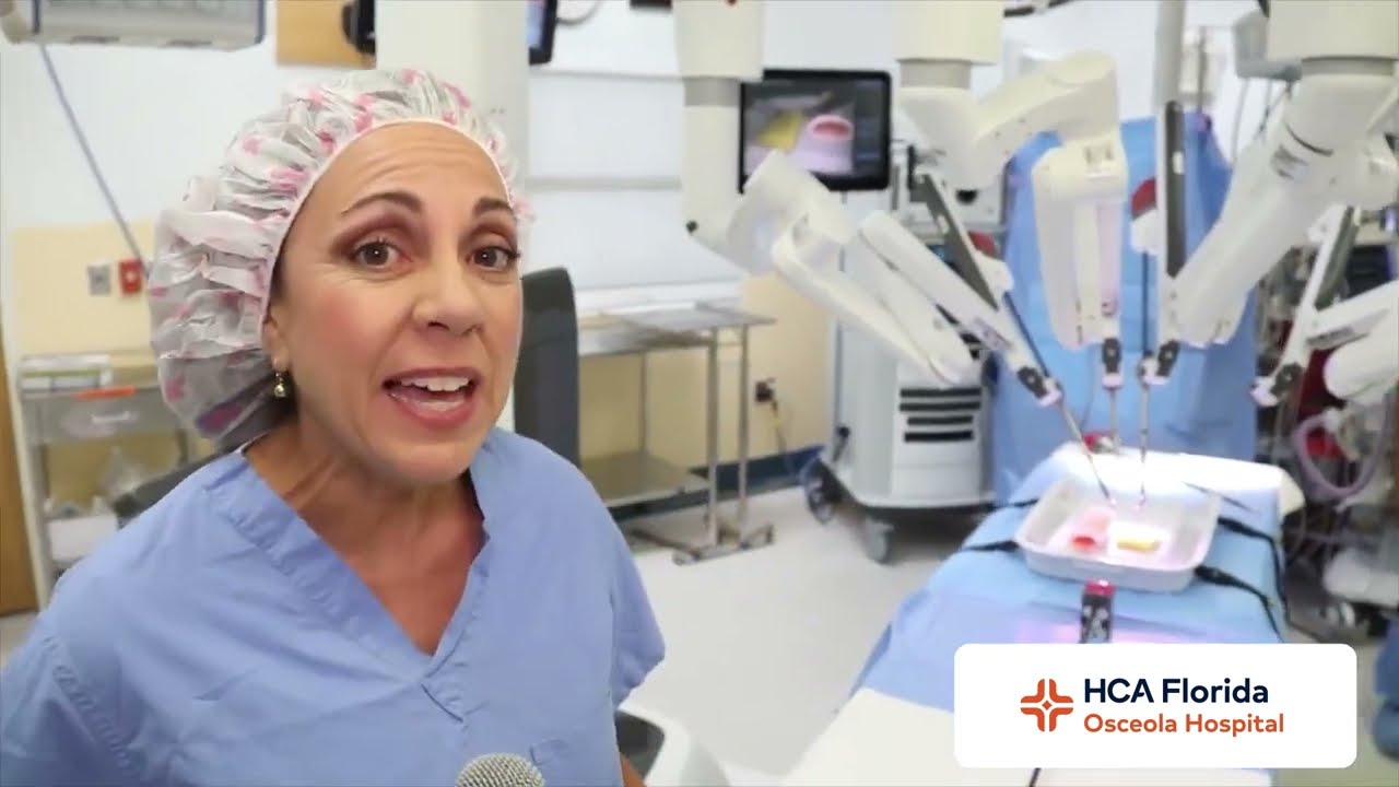 Alicia Mandigo stands in front of Robotic surgery device.