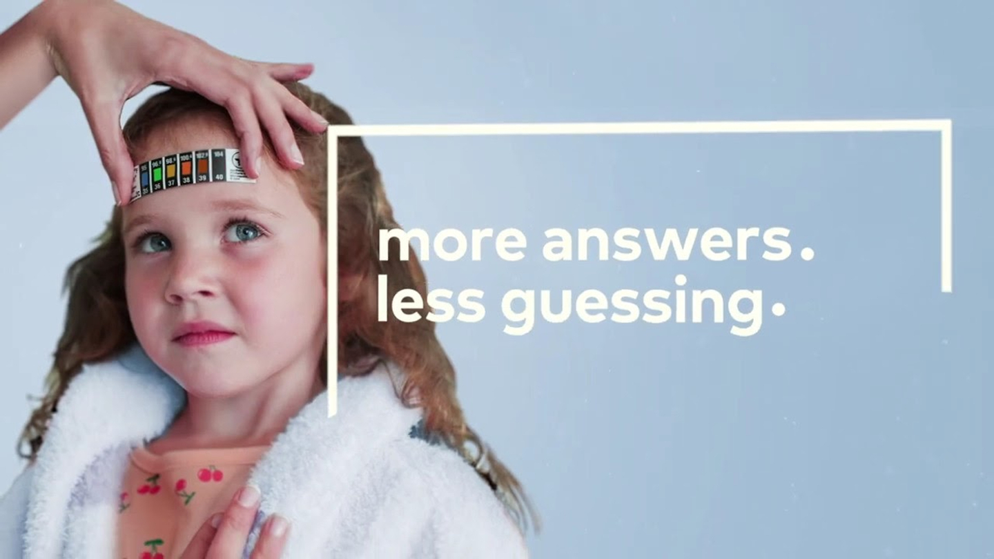 An adult takes a child's temperature using a forehead thermometer. Pictured text: More answers. Less guessing.