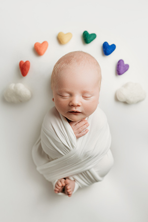 Precious baby Colby, swaddled with rainbow-colored hearts around the crown of his head.