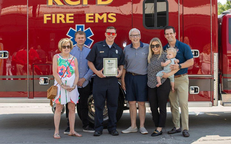 Steve Redmund, along with his family, smiles while standing with the EMS care team that responded to his 911 call.