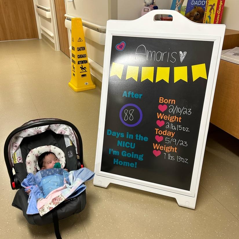 Amaris Lourdes Arredondo, NICU baby, next to stats chalkboard, about to be discharged