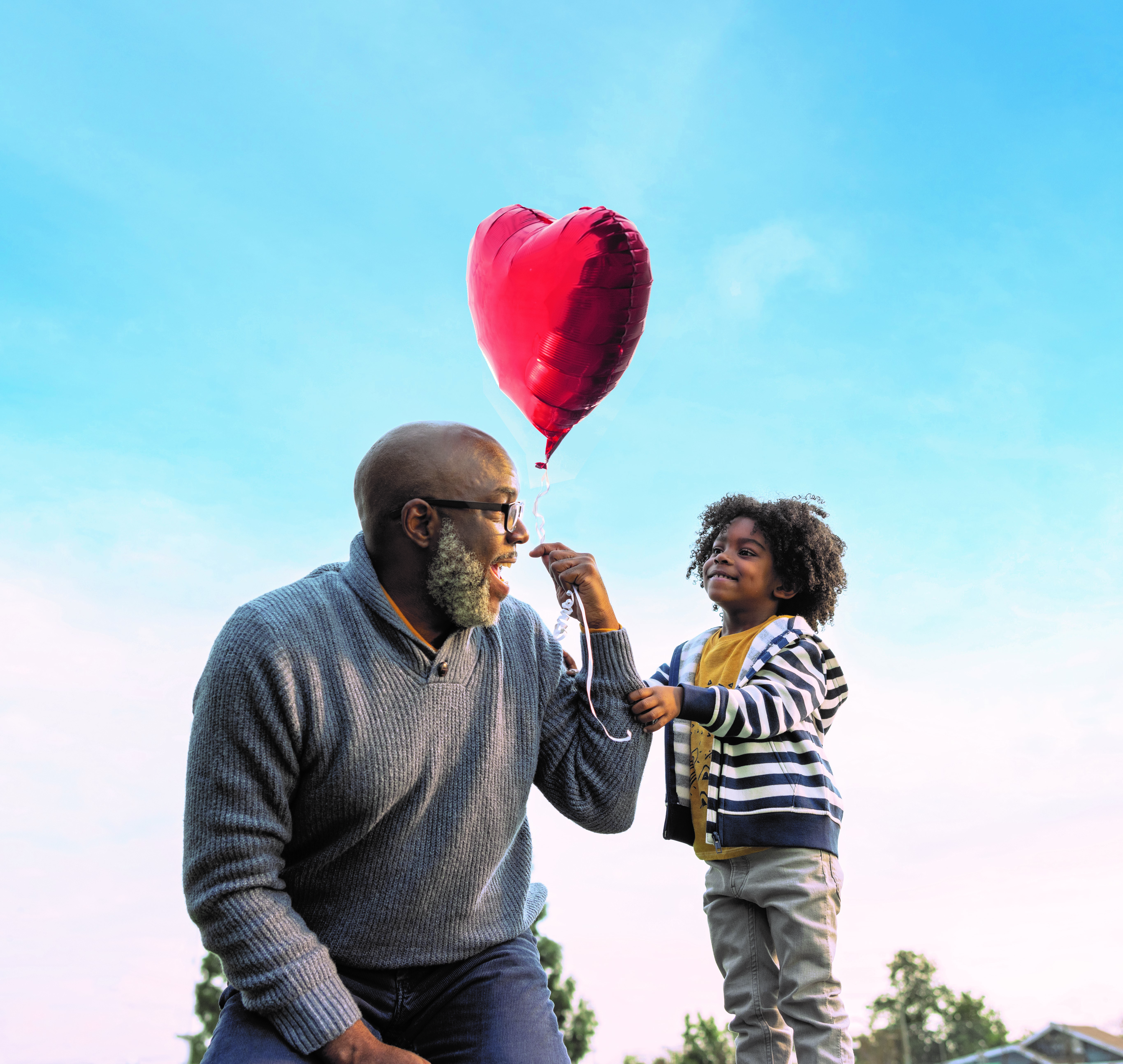 Grandpa and grandchild with balloon.