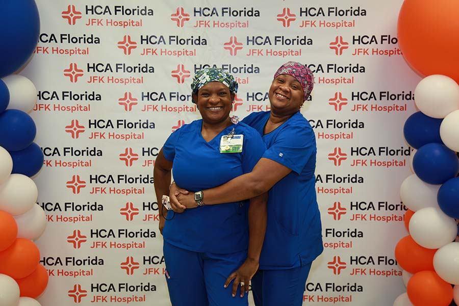 HCA Healthcare staff posing in front of new JFK Florida Hospital logo