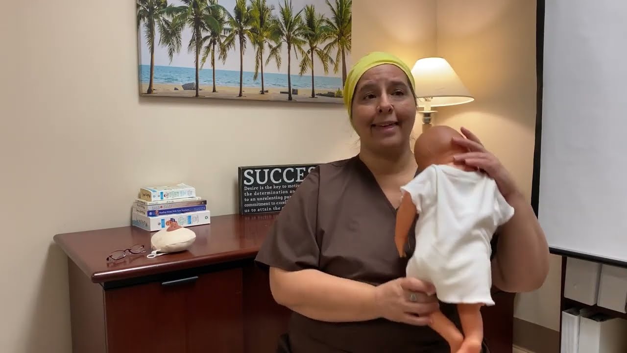 Lactation consultant, Sara Munoz, demonstrating burping a baby