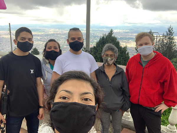 Linda smiles while wearing a cloth face mask and taking a selfie with her family.
