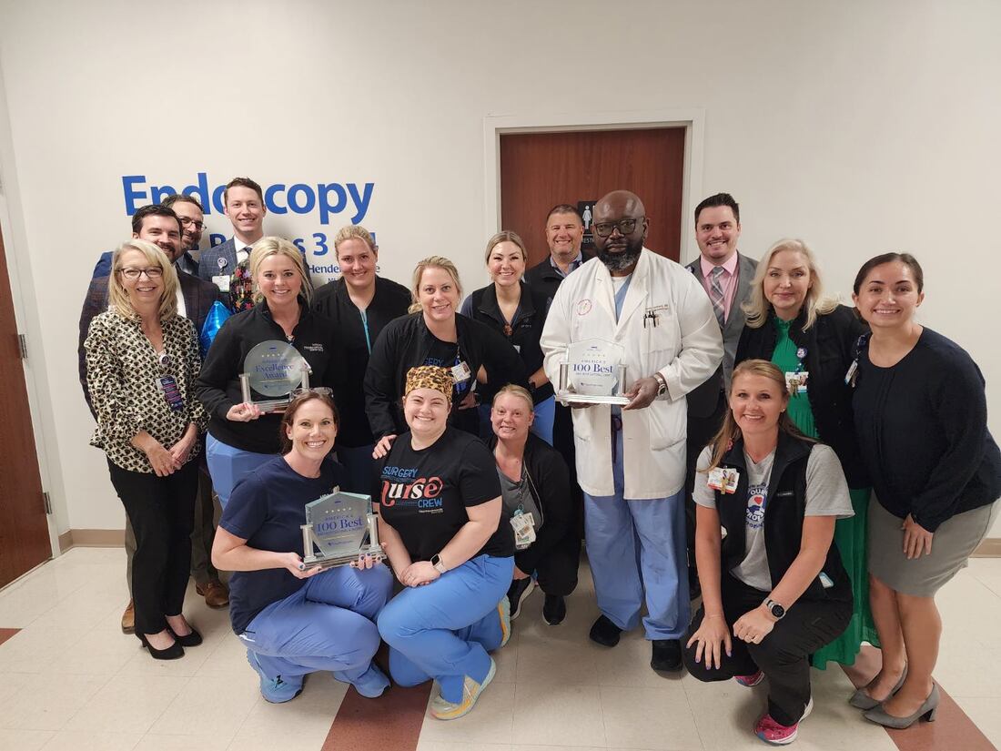 TriStar Hendersonville surgical team with their Healthgrades awards in front of Endoscopy door.