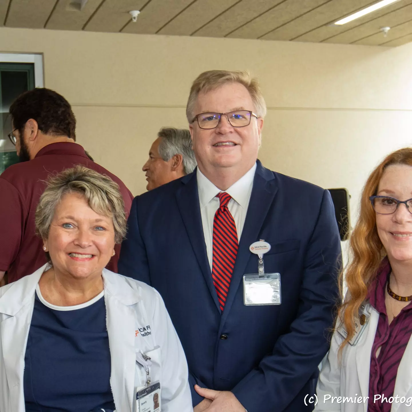 A distinguished group, two women and a man smiling at the camera.