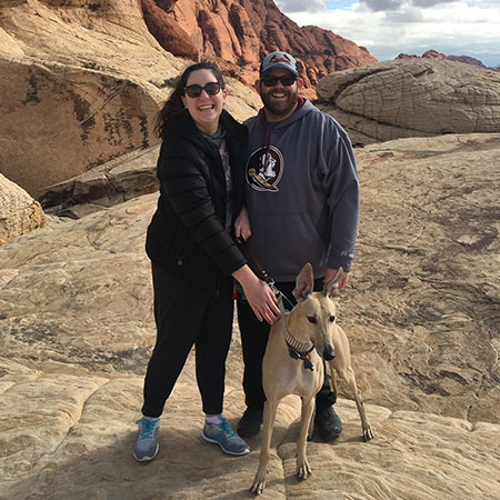 Derrick and Lauren Naegler with a dog in a canyon.