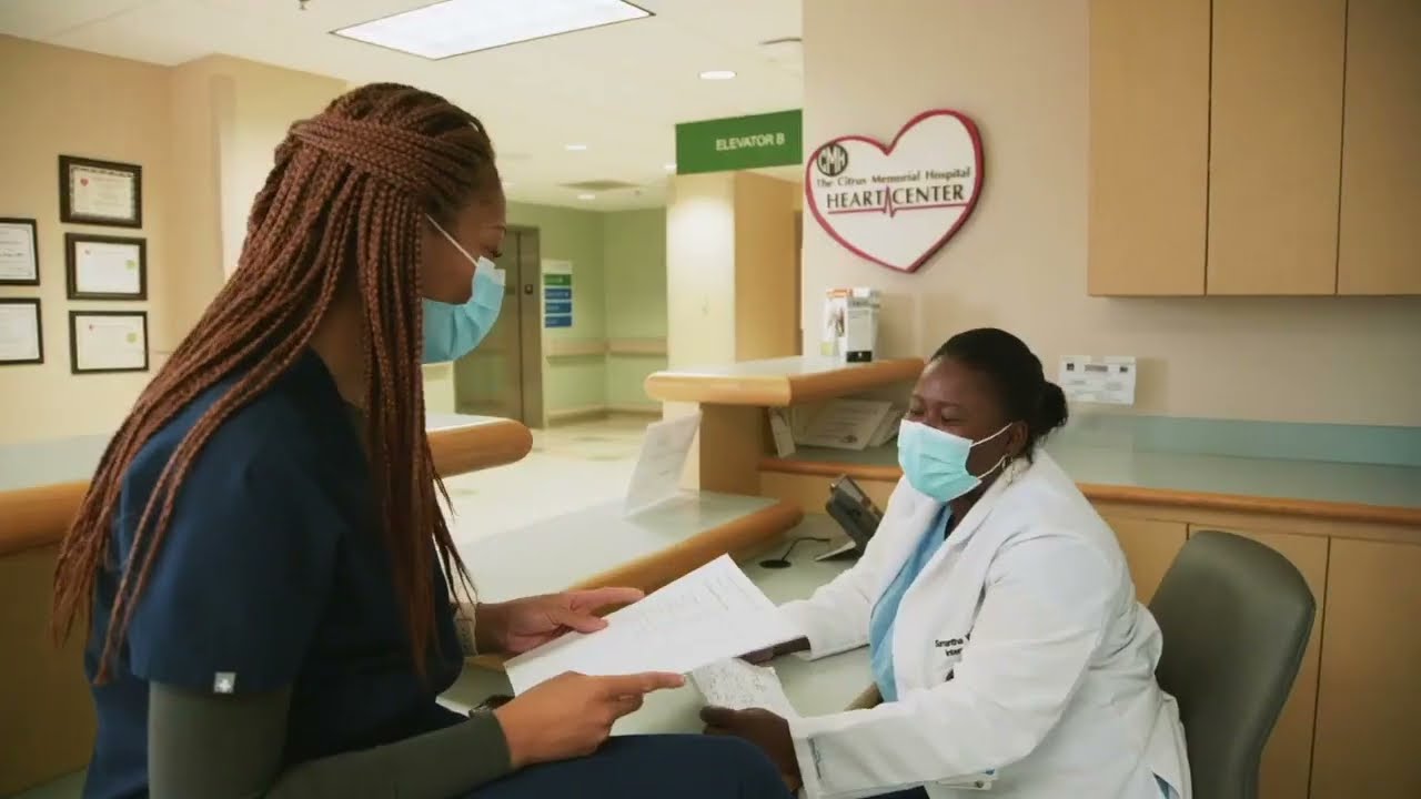 A Graduate Medical Education student talks with a Heart Center nurse at a nurses station.