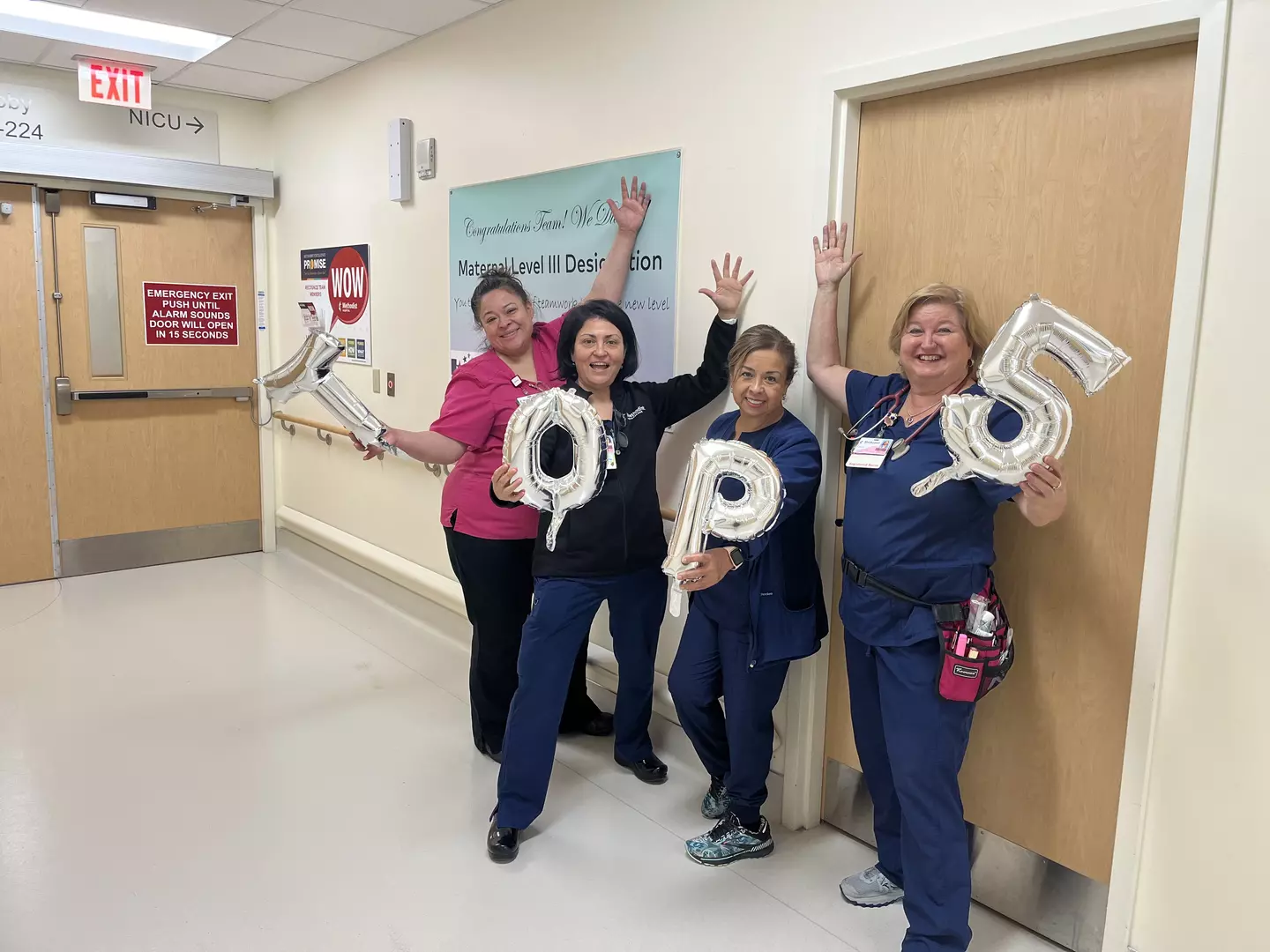 4 nurses holding balloons that spell out 'Top 5'.