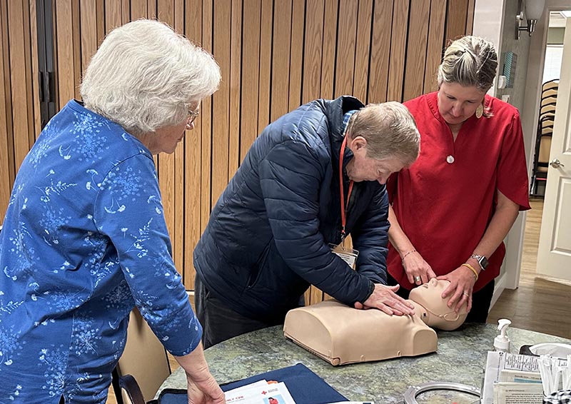 Women training CPR on mannequin
