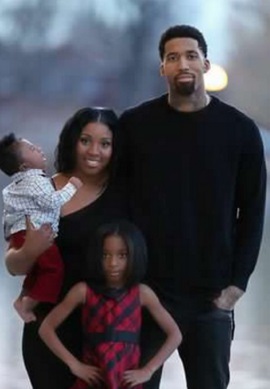 Arika Hall standing with her two kids and husband.