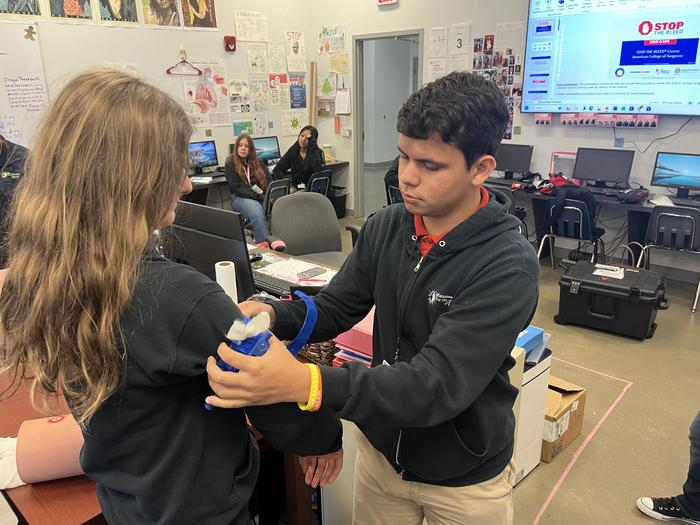 Two students practicing first aid technique.